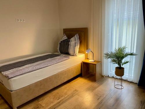 a bedroom with a bed and a potted plant at Pension Austria in Mitterdorf im Mürztal