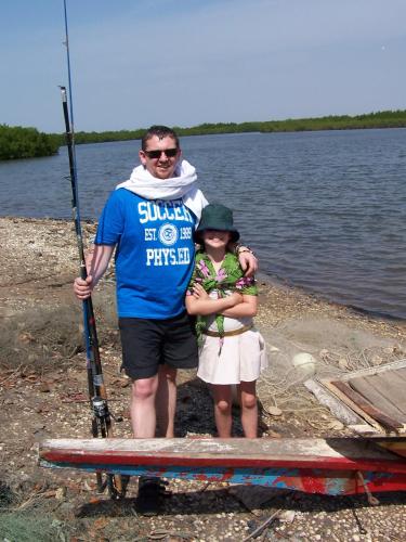 a man and a little girl standing on a paddle board at Jinack Lodge in Jinack Island