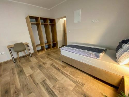 a bedroom with a bed and a wooden floor at Pension Austria in Mitterdorf im Mürztal