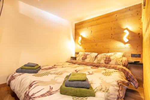 ラ・ジェッタにあるLe Cerf des Alpages - Appt cosy pour 2の木製の壁のベッドルーム1室(ベッド1台付)