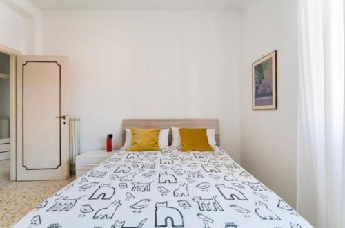 a white bedroom with a bed with yellow pillows at Casa Daniela&Mauro in Rome