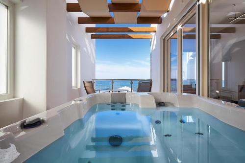 a swimming pool with a view of the ocean at Rodo Seafront Villa with Heated private pool and jacuzzis by Volta Suites and Villas in Kokkíni Khánion