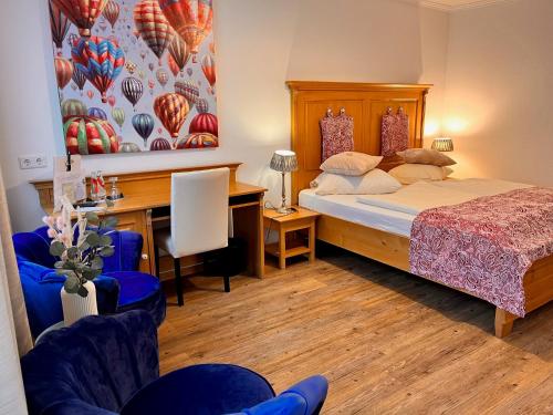 a bedroom with a bed and a desk and a table at Posthotel Arnold in Gunzenhausen