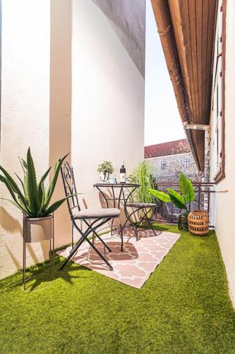 a room with a table and chairs and green grass at Elisabeth Residence - Home of the Gourmets in Sopron