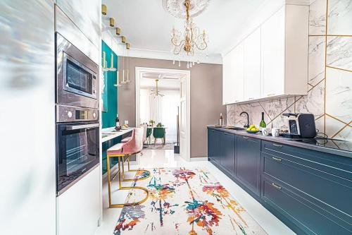 a kitchen with blue cabinets and a colorful rug on the floor at Elisabeth Residence - Home of the Gourmets in Sopron