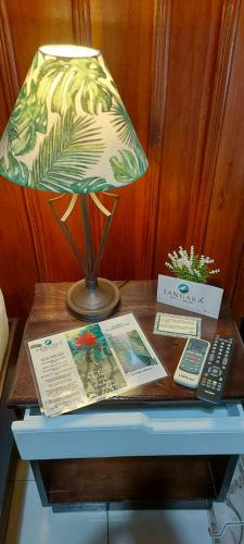 a table with a lamp and a book and a remote control at Casona Rústica & Bungalow in Fortuna