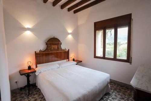 Un dormitorio con una gran cama blanca y una ventana en Villa Ca'n Pipeta, casa mallorquina centro Soller, en Sóller