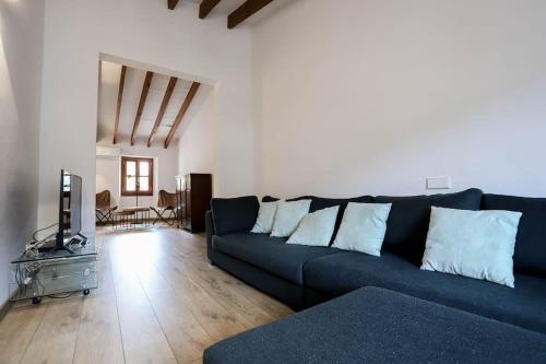 sala de estar con sofá azul y suelo de madera en Villa Ca'n Pipeta, casa mallorquina centro Soller, en Sóller