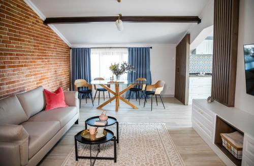 ein Wohnzimmer mit Sofa und Ziegelwand in der Unterkunft First Apartments in Focşani