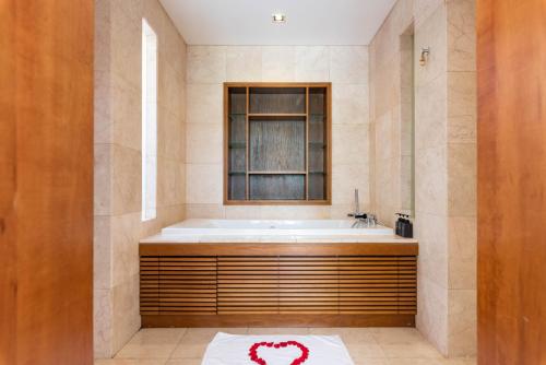 a bathroom with a bath tub and a window at Emblem Sea 2 bedroom villas in Da Nang