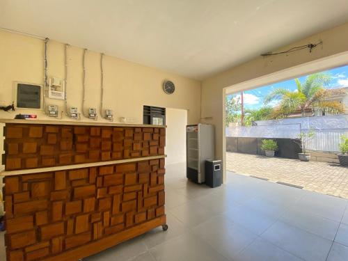 uma cozinha com um frigorífico e uma grande janela em De Homestay Mitra RedDoorz Bitung em Bitung