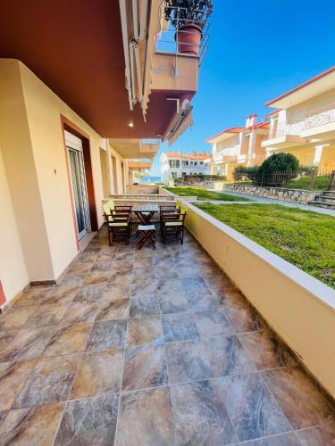 a patio with a table and chairs on a building at DARIVA apartment Nea Skioni in Nea Skioni
