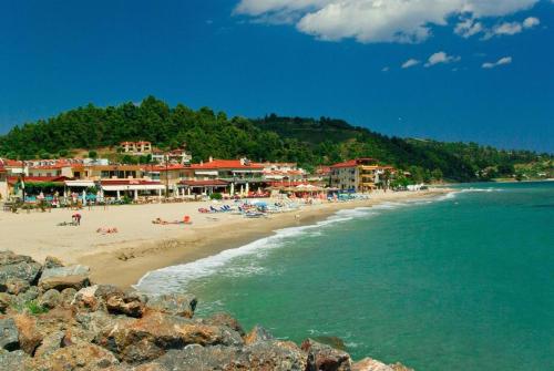 a beach with people laying on the sand and the water at DARIVA apartment Nea Skioni in Nea Skioni