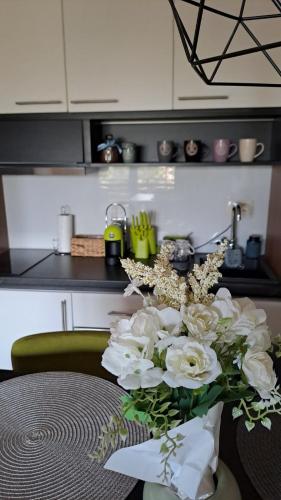 a vase with white flowers on a table in a kitchen at BalkanHill2 S37 Pekovic green in Zlatibor