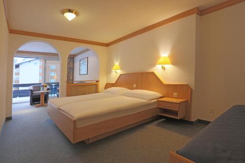 サースフェーにあるHotel Alpin Superiorのベッドルーム1室(ランプ2つ付)