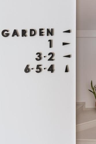 a sign that reads garden on a white wall at Petrou Suites in Ioannina