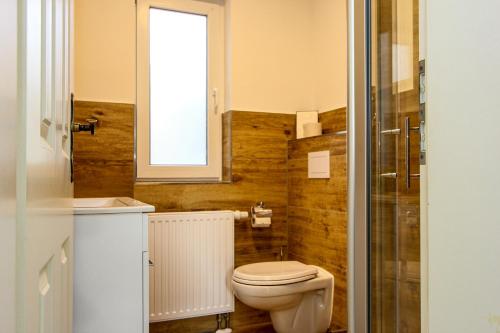 a bathroom with a toilet and a sink and a window at Lieblingshaus Eddie in Prerow
