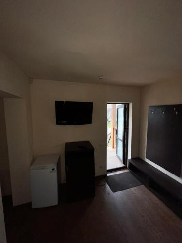 an empty living room with a television and a window at Baza Pădurice in Vadul lui Vodă