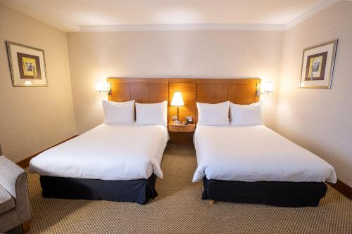 a hotel room with two beds and a couch at Crowne Plaza Brussels Airport by IHG in Zaventem