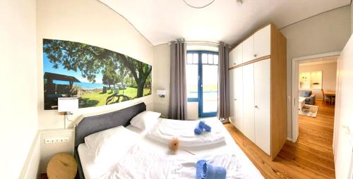 a bedroom with a bed with a large painting on the wall at Strandvilla Miramare in Boltenhagen