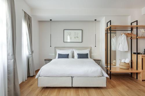a bedroom with a white bed and a wooden floor at Petrou Suites in Ioannina