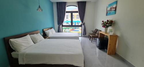 a hotel room with two beds and a window at BREAKING DAWN- TAEYANG Hotel Phú Quốc in Phu Quoc