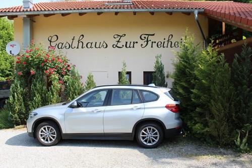a white car parked in front of a house at Pension Zur Freiheit in Passau
