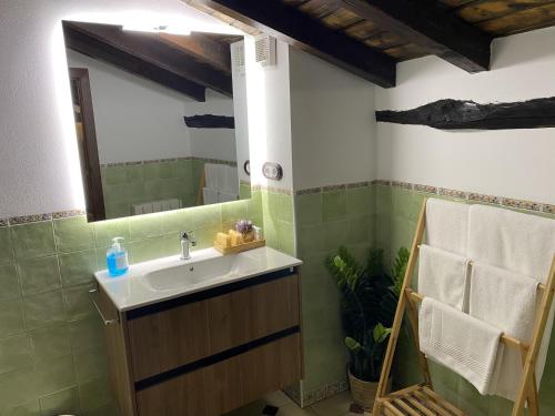 y baño con lavabo y espejo. en Apartamentos Rurales El Zarzo, en Hervás