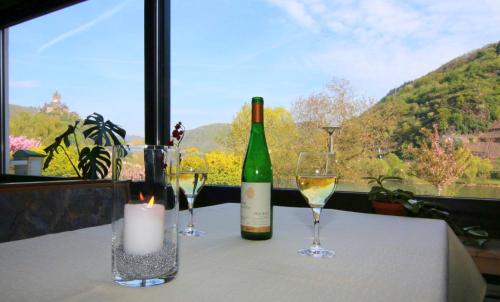 uma mesa com uma garrafa de vinho e dois copos em Hotel Klasen em Cochem