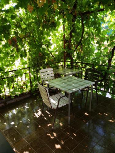 a table and chairs on a patio under a tree at Hostel Bela in Ohrid