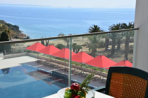 a balcony with a view of a swimming pool and the ocean at Grand Hotel Ontur Cesme in Cesme
