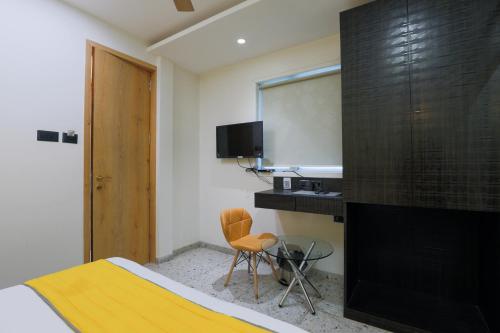 a bedroom with a bed and a desk and a television at The Cattleya Hotel, Near Mumbai International Airport in Mumbai