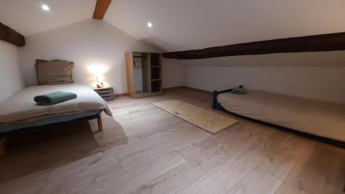 1 dormitorio con cama y alfombra en el suelo de madera en Appartement neuf et cosy 2 à 6 personnes tout équipé, en Allevard