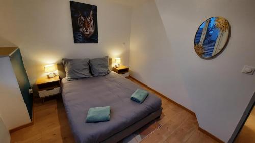 a bedroom with a large bed with two pillows on it at Appartement neuf et cosy 2 à 6 personnes tout équipé in Allevard