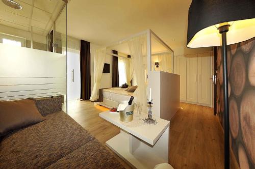 a living room with a couch and a table with a refrigerator at Hotel Florida in Levico Terme