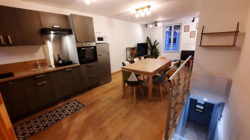 a kitchen and dining room with a table and chairs at Appartement neuf et cosy 2 à 6 personnes tout équipé in Allevard