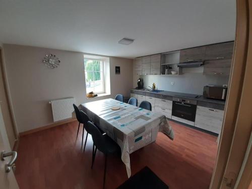 a kitchen with a table and chairs in a room at L'ANNEXE DE L'AMERIVIERE in Aubrives
