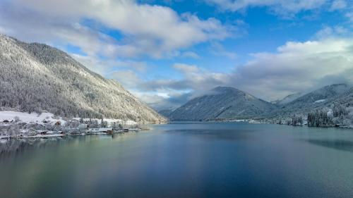 a view of a lake between two mountains at die weisse Wand in Weissensee