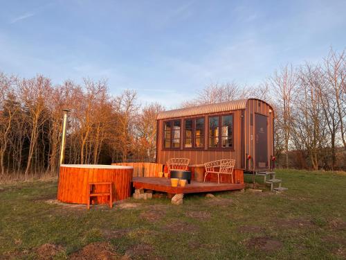 una casa pequeña sentada en un campo con un banco en Sol-flora, en Tjele