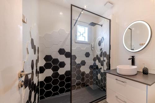 bagno con doccia, lavandino e specchio di ForestPlage Gîte avec SPA nordique a Cognac-le-Froid