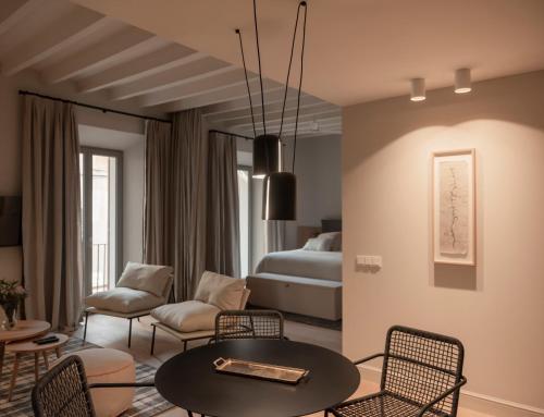 un soggiorno con letto, tavolo e sedie di Can Verí Suites a Sóller