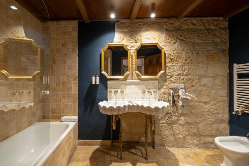 a bathroom with a bath tub and a sink at Hotel Cetina Palacio de los Salcedo in Baeza