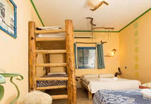 um quarto com 2 beliches e uma escada em Kfar Hanokdim - Desert Guest Rooms em Arad