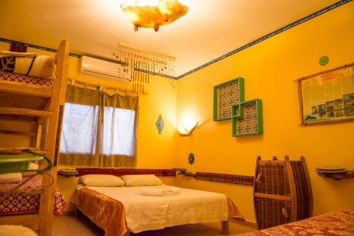 a room with two beds and a bunk bed at Kfar Hanokdim - Desert Guest Rooms in Arad