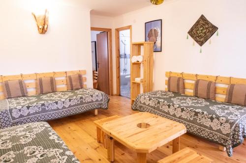 a living room with two couches and a wooden table at Kfar Hanokdim - Desert Guest Rooms in Arad