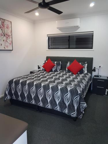 a bedroom with a black and white bed with red pillows at Athena Studio Units in Roma