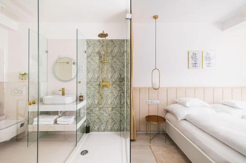 baño con ducha, cama y lavamanos en Birdies Rendezvényház Apartmanok, en Szentendre