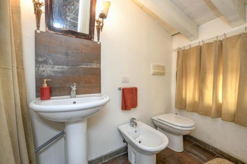 ein Bad mit einem Waschbecken und einem WC in der Unterkunft Appartamento Orchidea in Gargnano