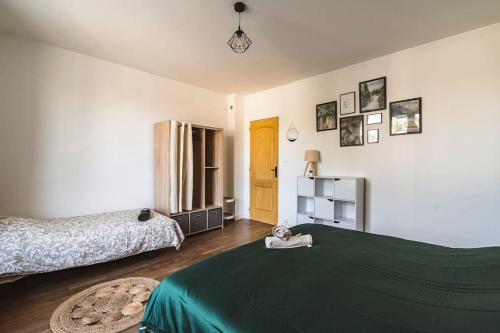 - une chambre avec 2 lits et une couverture verte dans l'établissement La "Tanière" pour 6 personnes, à Isles-sur-Suippe