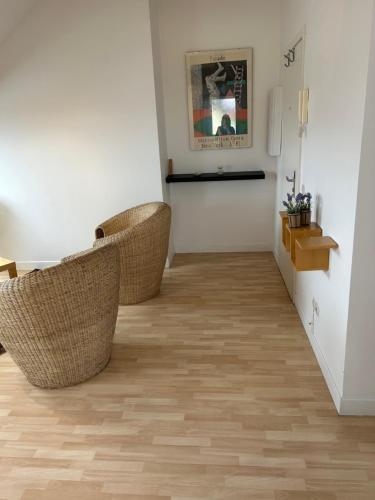 - un couloir avec des chaises en osier dans l'établissement Appartement - Stiring-Wendel, à Stiring-Wendel